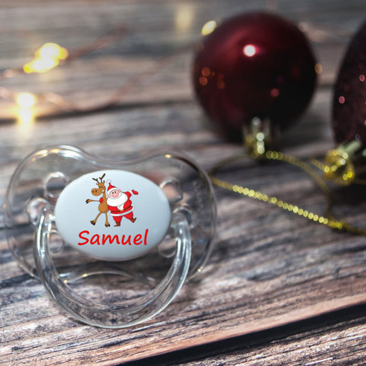 Personalised baby dummy with image of santa and baby's name.