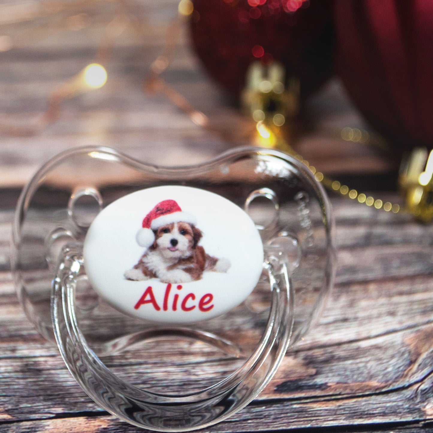 Personalised baby dummy with cute puppy wearing christmas hat.