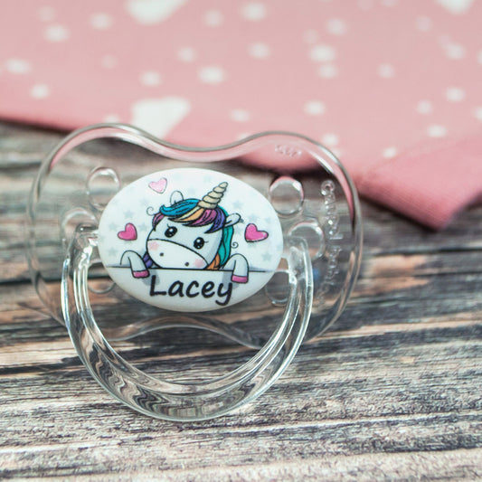 Personalised baby dummy with image of unicorn and hearts and name.